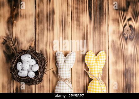 Composition de petits pains faits main carrés et d'œufs de caille à point blanc dans un nid brun. Célébration vacances de Pâques. Banque D'Images