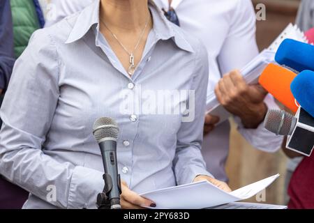 Une femme dénonciateur prononce un discours lors d'une conférence de presse ou d'un événement médiatique Banque D'Images