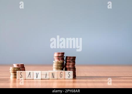 Les pièces de monnaie empilée empilent une boîte en bois avec des économies de mot de texte pour la planification de la phase de croissance, d'économiser de l'argent pour le fonds de retraite et le concept de plan futur. copier l'espace Banque D'Images