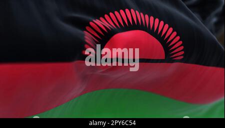 Vue rapprochée du drapeau national du Malawi. Tricolore de noir, rouge, rayures vertes, soleil levant rouge avec 29 rayons sur noir. Arrière-plan texturé en tissu. Banque D'Images