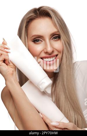 Belle fille blonde avec des cheveux parfaitement, et maquillage classique avec des produits cosmétiques. Beauté du visage et des cheveux. Banque D'Images