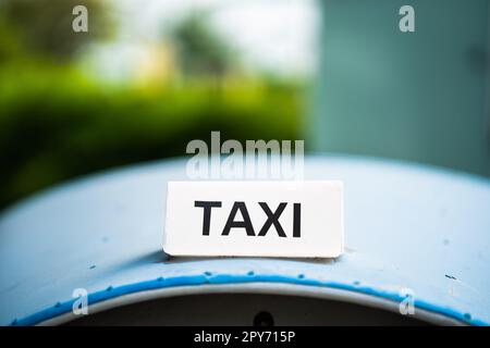 Panneau de taxi blanc sur le toit bleu. Banque D'Images