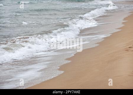 Laver l'eau sur la plage de sable sur l'image. Détail sur les petites vagues blanches formant. Mer Résumé arrière-plan. Banque D'Images