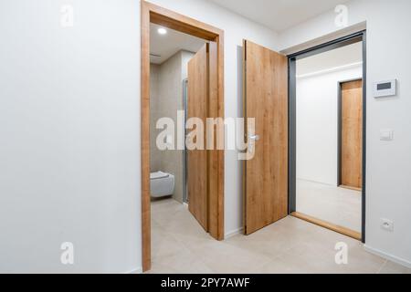 couloir dans l'appartement avec une porte à la salle de bains et d'autres chambres Banque D'Images