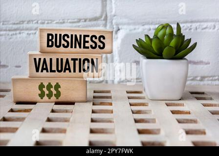 Évaluation commerciale. Blocs de bois montrant les mots. Arrière-plan vintage avec une fleur. Concepts de base de la finance. Thème commercial. conditions financières. Banque D'Images