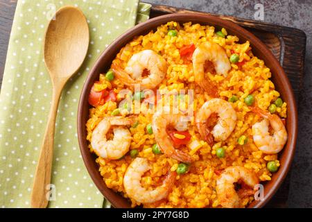 Riz jaune aux crevettes avec un peu d'ajout de légumes et d'épices dans un bol sur la table. vue horizontale du dessus Banque D'Images