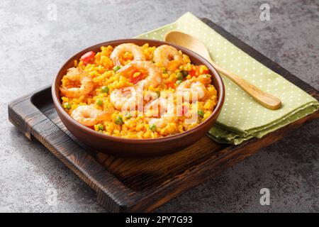 Riz jaune épicé aux crevettes et légumes dans un bol sur la table. horizontale Banque D'Images