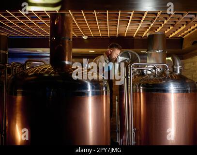 Bouilloire à ébullition en cuivre et réservoirs de distillerie dans une brasserie artisanale à bière Banque D'Images