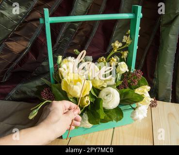 Women's hand holding wooden topper avec mot amour, fort avec les fleurs du printemps Banque D'Images