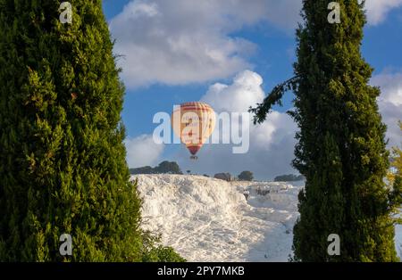 Ballons à air chaud et piscines naturelles de travertin au lever du soleil à Pamukkale, Denizli, Turquie Banque D'Images