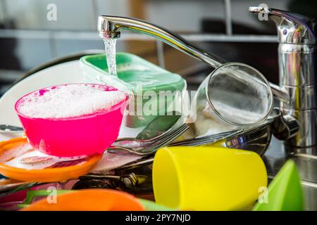 Évier de cuisine plein de vaisselle sale. Comptoir de couleur sombre dans la cuisine moderne. Concept de tâches domestiques Banque D'Images