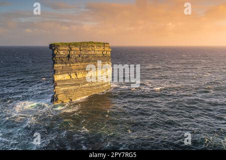 Downpatrick Head pile de mer illuminée par le lever du soleil, debout dans l'océan Atlantique, Irlande Banque D'Images