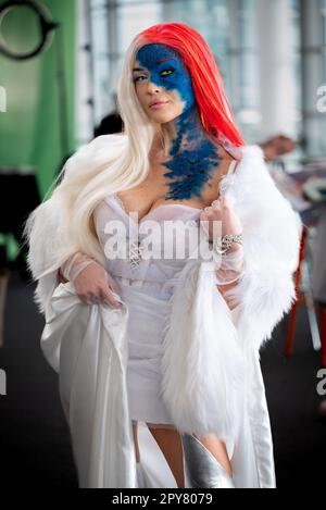 Une jeune femme pose dans un costume de cosplayer Mystique Banque D'Images