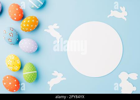 Au-dessus des œufs de pâques avec du papier de lapin coupé et du papier blanc circulaire Banque D'Images