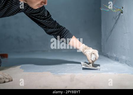 bricklayer fonctionne avec la truelle dans la chambre Banque D'Images