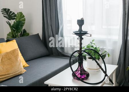 Chicha à narguilé avec flacon en verre et bol en métal dans le fond de la pièce. Vacances orientales traditionnelles pour la détente Banque D'Images