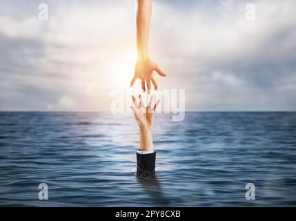 L'homme d'affaires se noie dans l'océan et reçoit de l'aide Banque D'Images