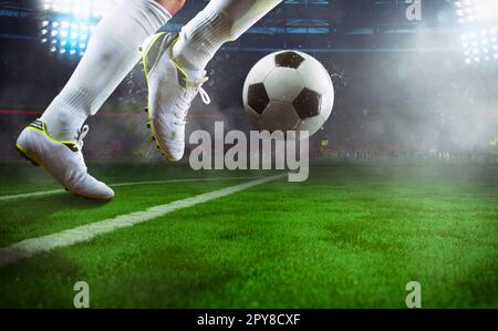 Scène de nuit football match avec près d'un joueur de football en marche pour lancer la balle dans le stade Banque D'Images