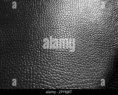 Texture cuir. Photographie monochrome noir et blanc. Gros plan. Cuir artificiel noir, matériel pour coudre des vêtements et des accessoires, rembourrage Banque D'Images