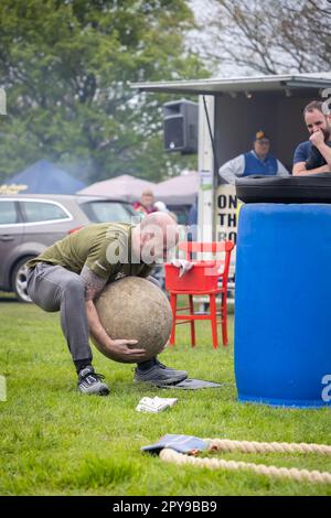 Culcheth, Royaume-Uni. Lundi 1 mai 2023, Culcheth, Angleterre - malgré les cieux gris et la bruine, Culcheth et Glazebury Community Day sur le green du village, qui propose des divertissements par Ian “Zippy” Lees, Northern Stars Dance & Fitness et le Mighty Smith strongman Show, avec des sidestals et des foires funestes. Adrian Smith encourage un membre de l'auditoire à soulever un crédit Pierre d'Atlas: John Hopkins/Alay Live News Banque D'Images