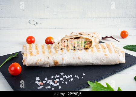 Délicieux sandwich au poulet shawarma avec salade et fromage sur fond de bois Banque D'Images