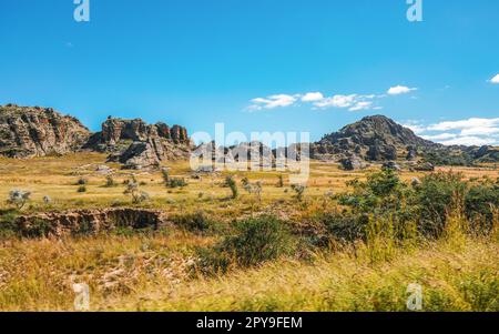 Faible croissance de l'herbe sur la savane africaine, petites montagnes rocheuses en arrière-plan - paysage typique au parc national d'Isalo, Madagascar Banque D'Images