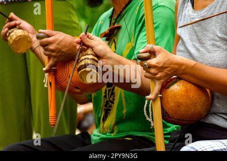 Musiciens jouant un instrument de percussions afro brésilien appelé un berimbau lors d'un spectacle de capoeira dans les rues du Brésil, au Brésil Banque D'Images