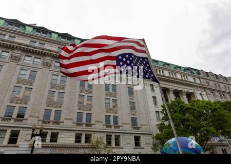 Un drapeau américain suspendu à l'envers dans un environnement venteux, avec les rayures et les étoiles de la bannière nationale qui flotte Banque D'Images