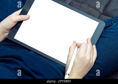 Tablette numérique avec écran blanc vierge dans les mains masculines, de la vue d'en haut. Travailler sur gadget portable avec stylet. Banque D'Images