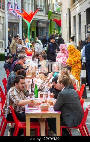 Londres, Royaume-Uni. 3 mai 2023. Des personnages costumés divertissent les clients qui dînent à une table de banquet de 80 mètres de long dans carter Lane près de Fleet Street, dans le cadre du « GRAND pique-nique » du quartier de Fleet Street. Inspiré par les jardins de Highgrove et en l'honneur de l'admiration du roi Charles III à l'égard des fleurs sauvages, cet événement est l'une des premières célébrations publiques pour le couronnement du roi Charles III Les activités extérieures de l’après-midi à carter Lane, Bream’s Buildings et Gough Square se poursuivent jusqu’au jeudi 4 mai. Credit: Stephen Chung / EMPICS / Alamy Live News Banque D'Images