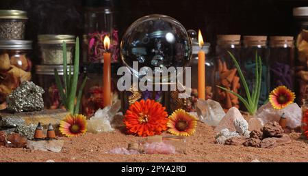 Boule de cristal avec bougies et pierres de chakra sur le sable rouge australien Banque D'Images