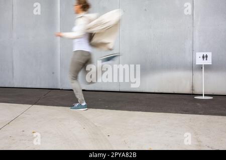 Femme se précipitant dans une salle de bains, toilettes, hygiène, toilettes. Notion d'urgence de WC. Banque D'Images