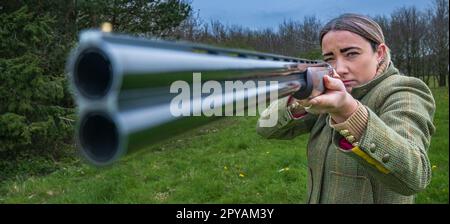 Une femme de plus de trente ans avec un fusil de chasse en gros regardant le canon Banque D'Images