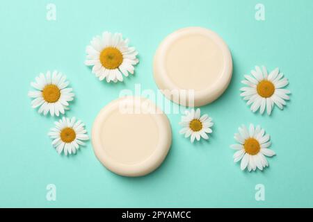 Composition Flat Lay avec barres de shampooing solides et chamomiles sur fond turquoise Banque D'Images