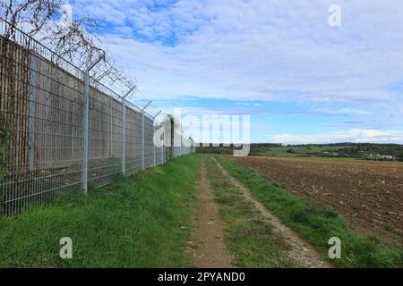 Le chemin de terre est parallèle à la clôture d'une propriété Banque D'Images