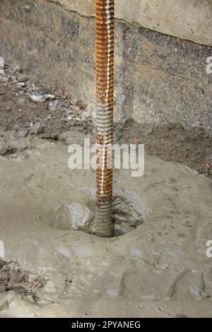 La barre de fer pour une fondation était ancrée au sol avec du béton Banque D'Images