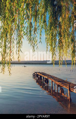 Coucher de soleil sur le lac de mer et ancienne jetée en bois, destination de voyage romantique, paysage de la nature Banque D'Images