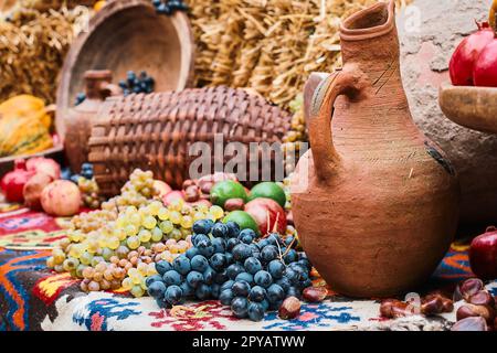 Carafe pour le vin et les petits pains de raisin sur un plateau. Mise au point sélective, arrière-plan flou. Encore la vie de fruits frais et de noix, saison de récolte. Écologique Banque D'Images