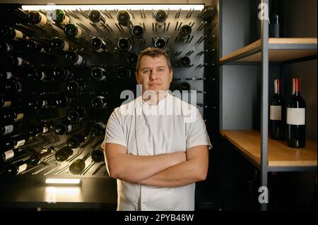 Portrait sommelier expert debout dans le magasin de vin et regardant l'appareil photo Banque D'Images