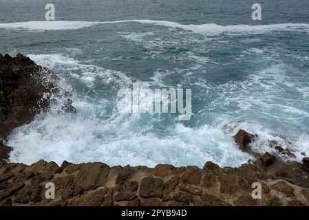 Vagues se brisant sur la rive sur une route de galets Banque D'Images