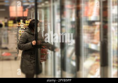 Une femme avec masque dans corona fois shopping Banque D'Images