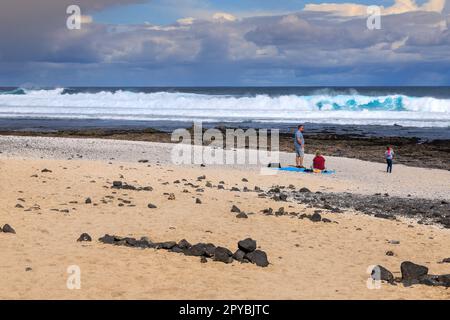 CORRALEJO, ESPAGNE - FÉVRIER 16: Les gens sont enraparés par le paysage à Playa del Bajo de la Burra (plage de Popcorn) sur 16 février 2023 à Corralejo, Espagne. En arrière-plan peut être vu les volcans de Lanzarote. Banque D'Images