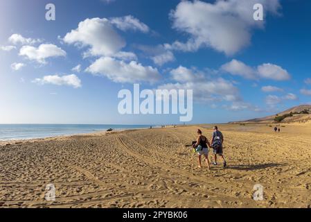 COSTA CALMA, ESPAGNE - FÉVRIER 18: (NOTE DE L'ÉDITEUR: Un filtre de couleur gradué a été utilisé pour cette image. L'image est un composite panoramique numérique.) Les gens marchent à la plage Playa Barca sur 18 février 2023 à Costa Calma, Espagne. Playa Barca fait partie de la longue plage Playa de Sotavento. Banque D'Images