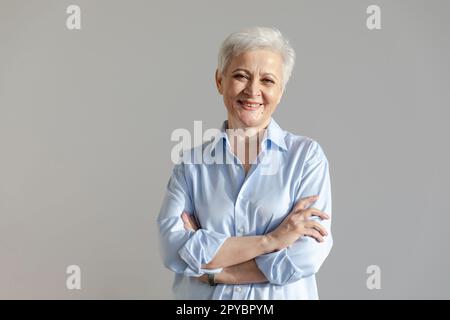 Femme européenne d'âge moyen confiante et élégante. Une femme âgée de 60s ans souriant sur fond blanc. Heureux belle femme regardant la photo gros plan visage portrait de tête. Des gens heureux Banque D'Images