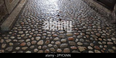 Pavés faits de pierres légères rondes semblables au marbre. Place pavée dans la vieille ville de Sarajevo, Bosnie-Herzégovine. Belles pierres brillantes humides après la pluie. Banque D'Images