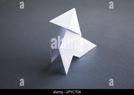 Poule de papier blanc origami isolé sur fond gris Banque D'Images