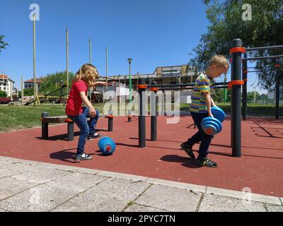 Sremska Mitrovica, Serbie. 6 juin 2020. Tongs, musculation et haltères, exercices de musculation. Deux adolescents font du sport sur des simulateurs, des enfants sur un terrain de sport Banque D'Images