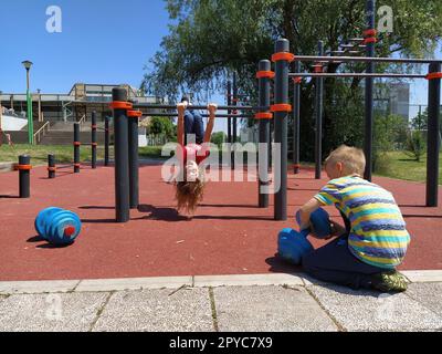 6 juin 2020, Sremska Mitrovica, Serbie. Les enfants font du sport sur l'aire de jeux. Exercices avec kettlebells. Poids de levage. Éducation physique et sport. Amusement des enfants en été Banque D'Images