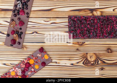 différents types de chocolat avec fruits séchés sur une planche en bois Banque D'Images