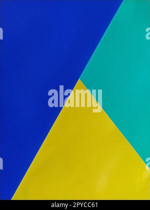 Papier bleu, vert et jaune empilés les uns sur les autres. Fond coloré Banque D'Images